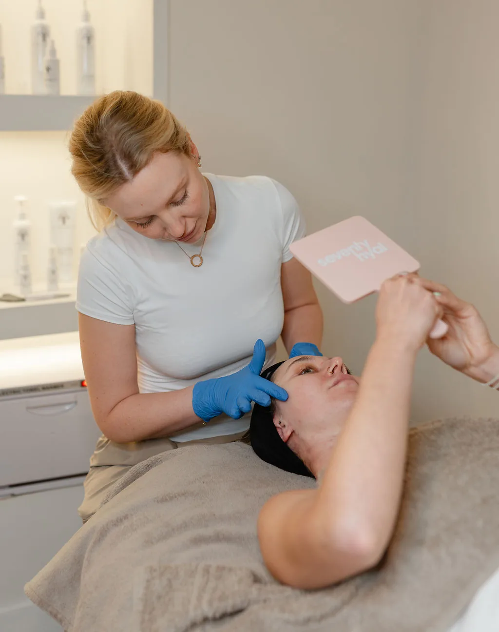 Client checking her glow in a Seventy Hyal mirror after a skin booster treatment at The Skin Lounge Bristol
